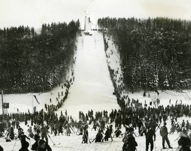Historische Schwarzweißfotografie des Wintersportplatzes von Münsingen-Auingen. Zu sehen ist vor allem die Skisprungschanze "Hardt-Schanze".