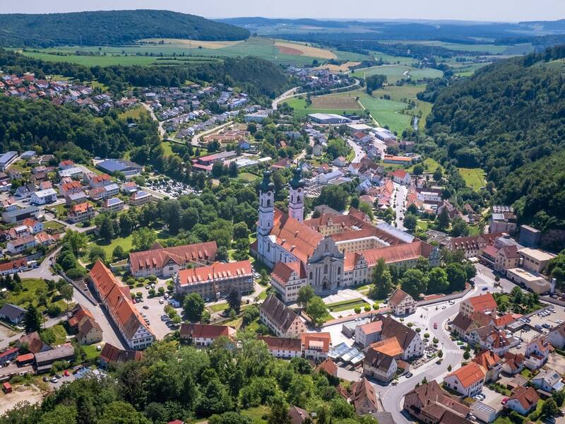 Luftbildaufnahme von Zwiefalten. Im Fokus des Bildes steht der Zwiefalter Münster.